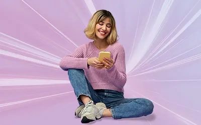Teenage girl sat cross legged holding her phone